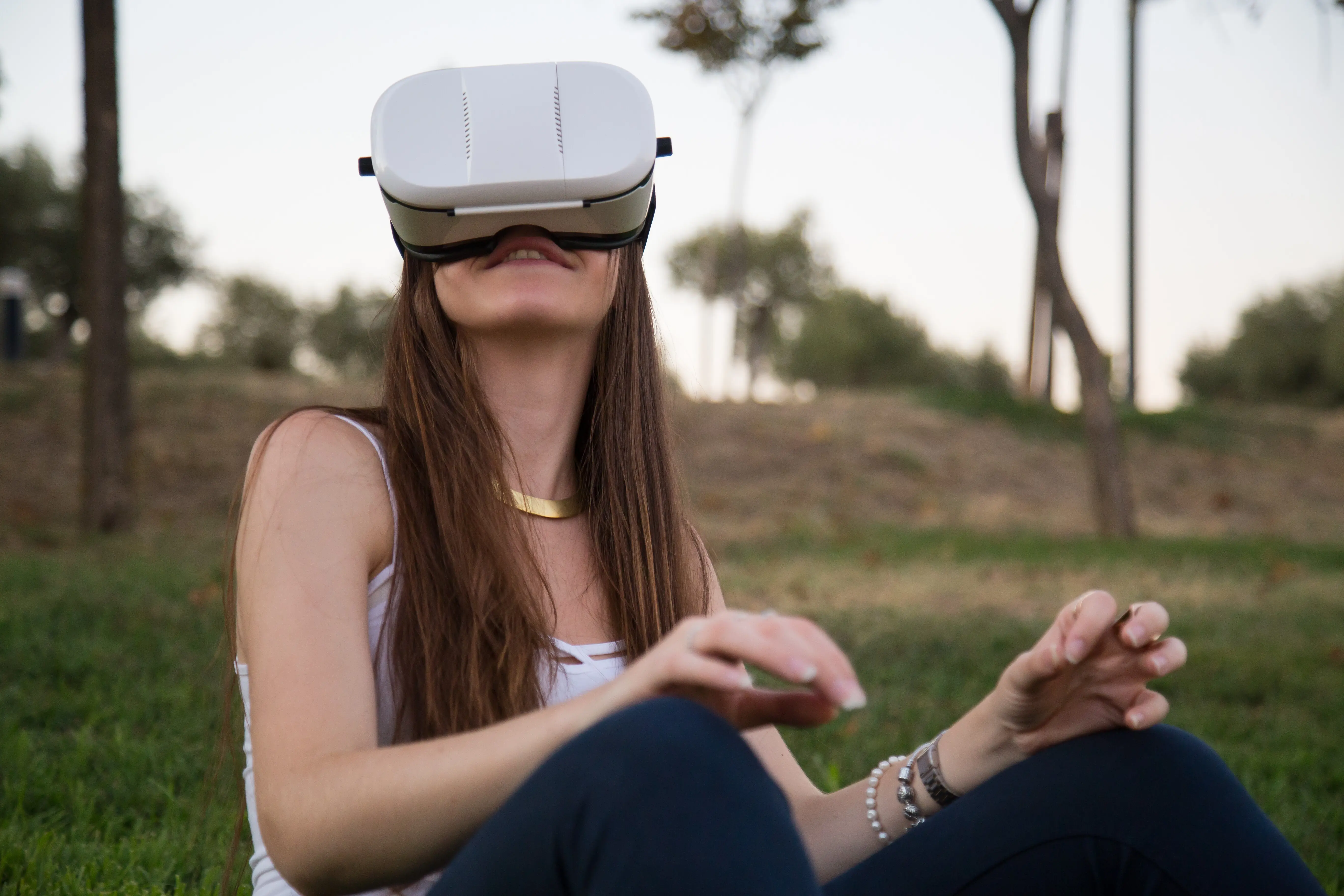 Junge Frau nutzt einen Virtual-Reality-Simulator und hat dabei Spaß im Park.